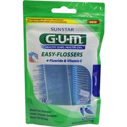 Eine Packung Zahnseide-Sticks mit Fluorid und Vitamin E in grünem Beutel.